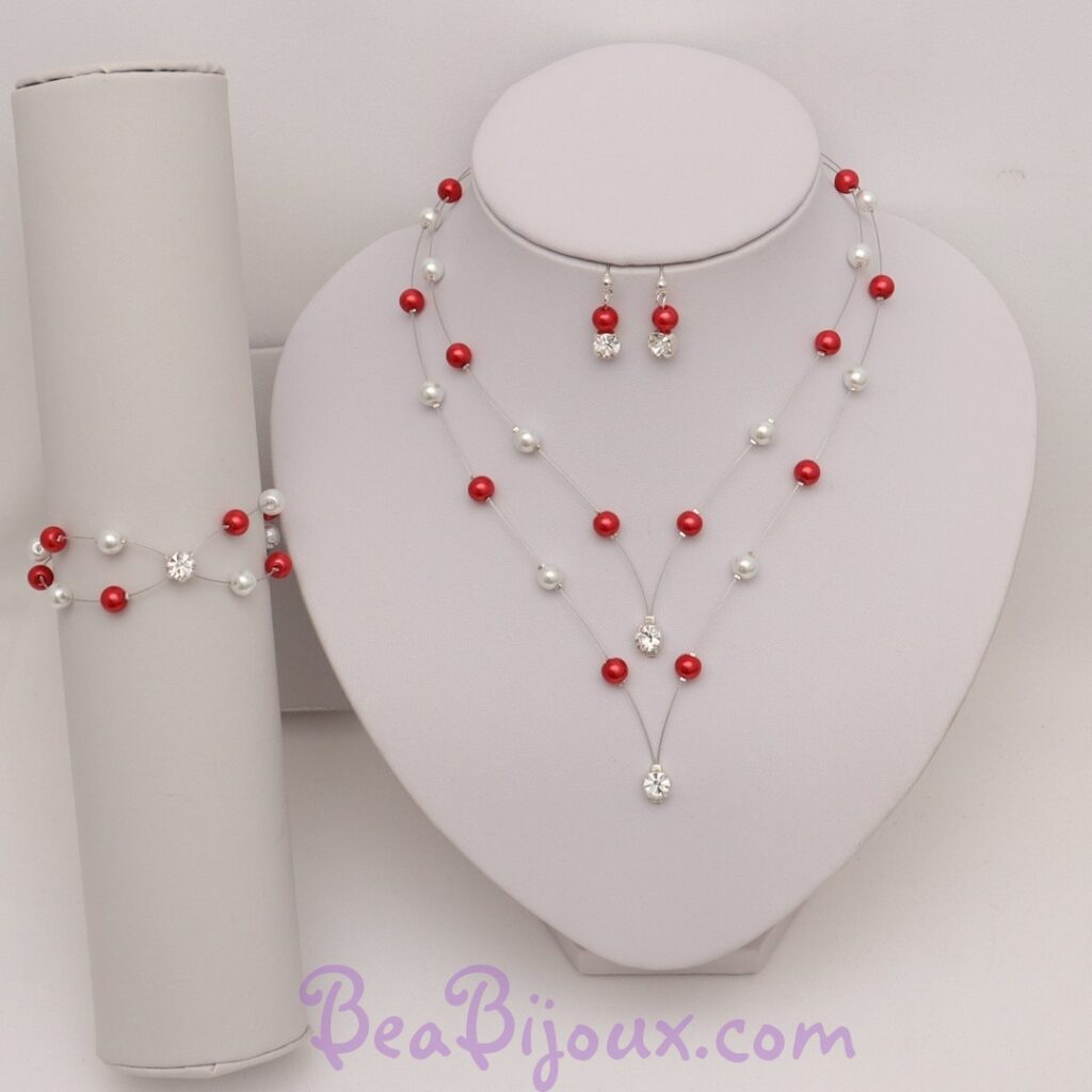 Parure complète PA1276A composée d'un collier en pointe, d'un bracelet et de boucles d'oreilles en perles nacrées rouges et blanches.