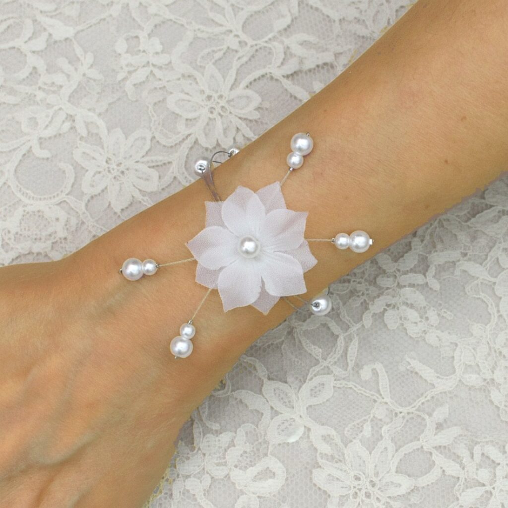 Bijou de poignet mariée avec double fleur en soie blanche et perles nacrées sur fil câblé.